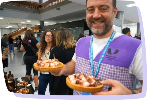 Foto da WordCamp Pontevedra 2022 na que se ve a un voluntario sostendo pratos con polbo.